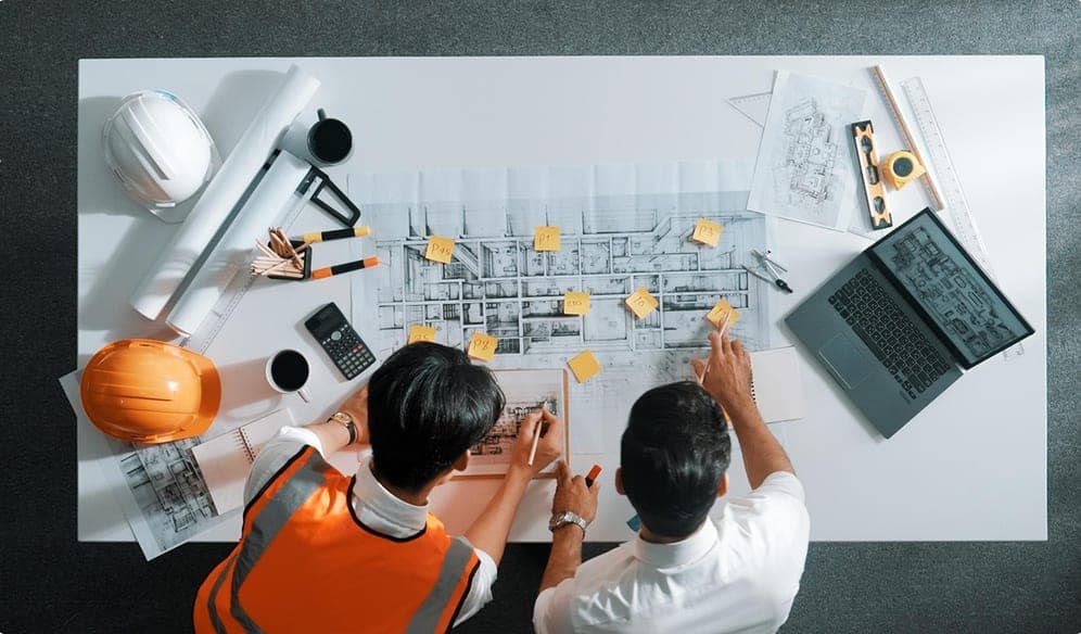Construction engineers reviewing design drawings together